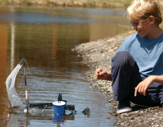 Kid building and floating Uberstix boat
